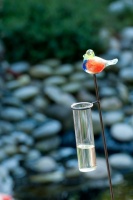Regenmeter met glazen vogeltje